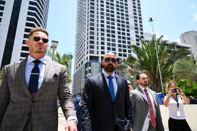 Joseph D. McBride (C), attorney for Andrew Tate and Tristan Tate, and Justin Waller (L) depart following a hearing for the Tate brothers at the C. Clyde Atkins US Courthouse in Miami, Florida, on July 20, 2026. Radical social media influencer Andrew Tate and his brother Tristan were in custody in the US on July 19,  officials said, as Britain seeks their extradition to face new charges of rape, sex trafficking and assault. (Photo by CHANDAN KHANNA / AFP)