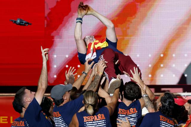 Spain's coach Luis de la Fuente is tossed by players as they celebrate on a stage at Cibeles Square in Madrid on July 20, 2026, one day after winning their second World Cup title following a 1-0 victory against Argentina. Spain's World Cup winners come back home to a heroes' welcome in Madrid, where a million fans are expected to greet them after a night of raucous celebrations across the country. (Photo by Oscar DEL POZO / AFP)