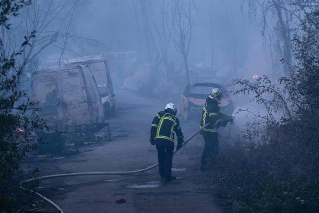 Firefighters extinguish a fire which destroyed nearly 10 hectares of vegetation near a "shantytown" in Nantes, western France, on July 20, 2026. According to local media, the fire whose plumes of black smoke were visible from many neighbourhoods in Nantes broke out near a travellers’ camp. The fire service, which mobilised nearly 150 personnel, reported that the fire had "spread significantly to makeshift dwellings". (Photo by Sebastien Salom-Gomis / AFP)