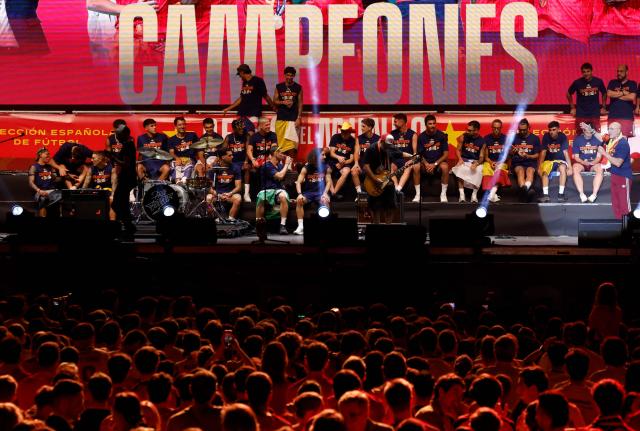Spain's coach Luis de la Fuente (R) speaks as Spain's team celebrate on a stage at Cibeles Square in Madrid on July 20, 2026, one day after winning their second World Cup title following a 1-0 victory against Argentina. Spain's World Cup winners come back home to a heroes' welcome in Madrid, where a million fans are expected to greet them after a night of raucous celebrations across the country. (Photo by Oscar DEL POZO / AFP)