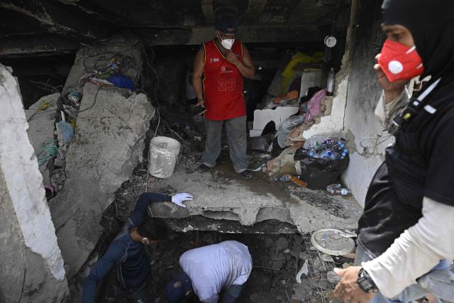Volunteers and relatives of victims search for the bodies of their loved ones under the rubble of a building destroyed by the June 24 earthquakes in Caraballeda, Venezuela, on July 20, 2026. (Photo by Federico PARRA / AFP)