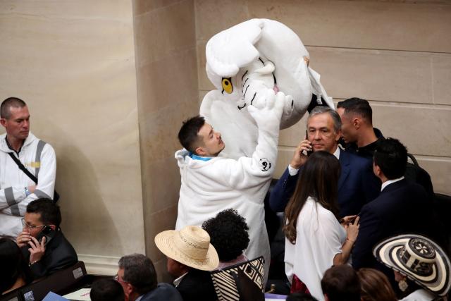 Newly elected Colombian senator Luis Carlos Rua, known as the activist "White Elephant", holds the head of an elephant costume during the installation of the ordinary sessions of Congress in Bogota on July 20, 2026. (Photo by ESTEBAN VEGA LA-ROTTA / AFP)