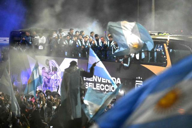 Argentina's national football team rides aboard an open-top bus as it arrives at the Argentine Football Association (AFA) training camp in Ezeiza, Buenos Aires Province, on July 20, 2026, after returning from the United States following its defeat in the 2026 FIFA World Cup final. (Photo by Luis ROBAYO / AFP)