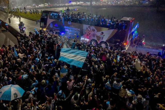 In this aerial view Argentina's national football team rides aboard an open-top bus as it arrives at the Argentine Football Association (AFA) training camp in Ezeiza, Buenos Aires Province, on July 20, 2026, after returning from the United States following its defeat in the 2026 FIFA World Cup final. (Photo by Tomas CUESTA / AFP)