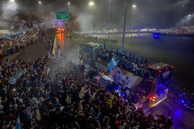 In this aerial view Argentina's national football team rides aboard an open-top bus as it arrives at the Argentine Football Association (AFA) training camp in Ezeiza, Buenos Aires Province, on July 20, 2026, after returning from the United States following its defeat in the 2026 FIFA World Cup final. (Photo by Tomas CUESTA / AFP)