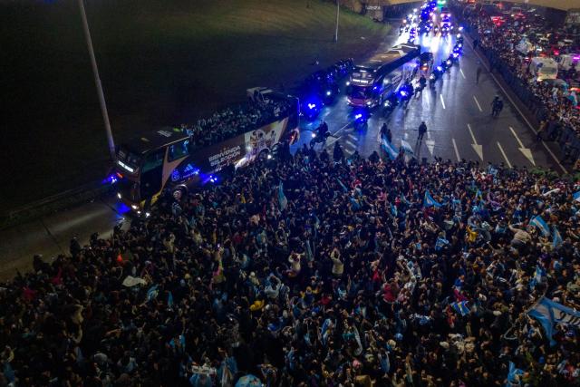 In this aerial view Argentina's national football team rides aboard an open-top bus as it arrives at the Argentine Football Association (AFA) training camp in Ezeiza, Buenos Aires Province, on July 20, 2026, after returning from the United States following its defeat in the 2026 FIFA World Cup final. (Photo by Tomas CUESTA / AFP)