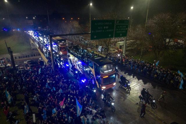 In this aerial view Argentina's national football team rides aboard an open-top bus as it arrives at the Argentine Football Association (AFA) training camp in Ezeiza, Buenos Aires Province, on July 20, 2026, after returning from the United States following its defeat in the 2026 FIFA World Cup final. (Photo by Tomas CUESTA / AFP)