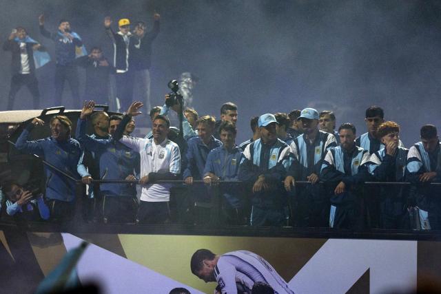 Argentina's head coach Lionel Scaloni (3-L) and members of Argentina's national football team wave aboard an open-top bus as they drive towards the Argentine Football Association (AFA) training camp in Ezeiza, Buenos Aires Province, on July 20, 2026, after returning from the United States following their defeat in the 2026 FIFA World Cup final. (Photo by TOMAS CUESTA / AFP)