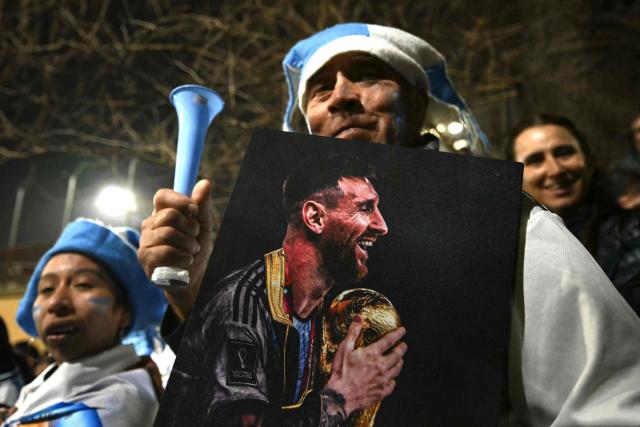 A fan holding a portrait of Argentina's forward Lionel Messi gathers near the Argentine Football Association (AFA) training camp in Ezeiza, Buenos Aires Province, on July 20, 2026, while waiting for the arrival of Argentina's national football team from the United States following its defeat in the 2026 FIFA World Cup final. (Photo by Luis ROBAYO / AFP)
