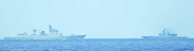 In this handout photo released by the Japanese Ministry of Defence on July 21, 2026, a Chinese Navy Luyang III-class guided-missile destroyer (L) and a Russian Navy Steregushchiy-class frigate conduct live-fire training  exercises within Japan's exclusive economic zone (EEZ) according to the defence ministry. (Photo by Handout / various sources / AFP) / Japan OUT