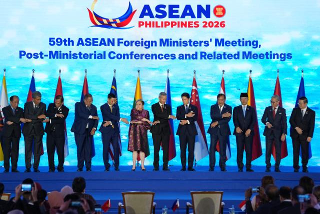 (L-R) Myanmar Permanent Secretary Hau Khan Sum, Malaysia's Foreign Minister Mohamad Hasan, Thailand's Foreign Minister Sihasak Phuangketkeow, East Timor's Foreign Minister Bendito dos Santos Freitas, Vietnam's Deputy Minister of Foreign Affairs Dang Hoang Giang, Philippine Foreign Secretary Theresa Lazaro, Singapore's Foreign Minister Vivian Balakrishnan, Brunei's Foreign Minister Abdul Mateen Bolkiah, Cambodia's Foreign Minister Prak Sokhonn, Indonesia's Foreign Minister Sugiono, Laos Foreign Minister Thongsavanh Phomvihane and ASEAN Secretary-General Kao Kim Hourn hold hands during the opening ceremony of the Association of Southeast Asian Nations (ASEAN) Foreign Ministers' Meeting in Pasay, Metro Manila on July 21, 2026. (Photo by Aaron Favila / POOL / AFP)