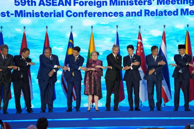 (L-R) Malaysia's Foreign Minister Mohamad Hasan, Thailand's Foreign Minister Sihasak Phuangketkeow, East Timor's Foreign Minister Bendito dos Santos Freitas, Vietnam's Deputy Minister of Foreign Affairs Dang Hoang Giang, Philippine Foreign Secretary Theresa Lazaro, Singapore's Foreign Minister Vivian Balakrishnan, Brunei's Foreign Minister Prince Abdul Mateen Bolkiah, Cambodia's Foreign Minister Prak Sokhonn and Indonesia's Foreign Minister Sugiono hold hands for a group photo during the opening ceremony of the Association of Southeast Asian Nations (ASEAN) Foreign Ministers' Meeting in Pasay, Metro Manila on July 21, 2026. (Photo by Aaron Favila / POOL / AFP)