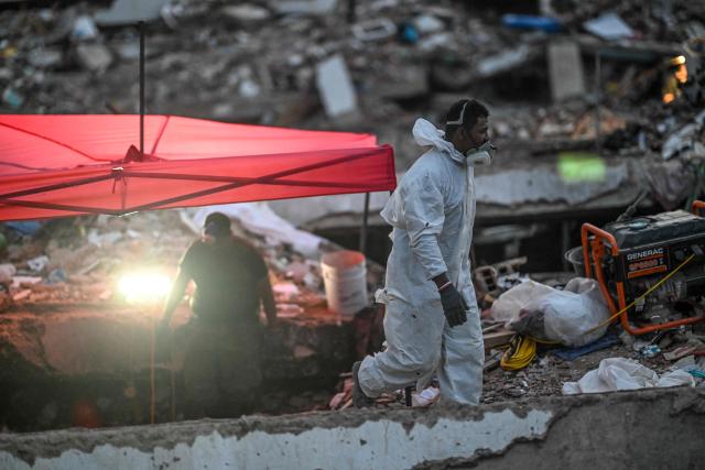 A forensic worker walks amid the rubble of a residential building that collapsed following the June 24 earthquakes, in Caraballeda, Venezuela, on July 20, 2026. The number of people killed in the powerful dual Venezuela earthquakes last month rose to 5,278, according to official figures updated Monday. The June 24 earthquakes, which recorded magnitudes of 7.2 and 7.5, profoundly impacted the north of the country, particularly the coastal state of La Guaira, near the capital Caracas. (Photo by Juan BARRETO / AFP)