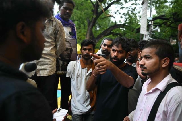 Cockroach Janta Party (CJP) founder Abhijeet Dipke speaks to a victim who was injured during a protest demanding the resignation of India's Education Minister Dharmendra Pradhan over alleged NEET exam irregularities, in New Delhi on July 21, 2026. India's "Cockroach" party movement vowed on July 21 to press ahead with their campaign until Education Minister Dharmendra Pradhan resigns. (Photo by Arun SANKAR / AFP)