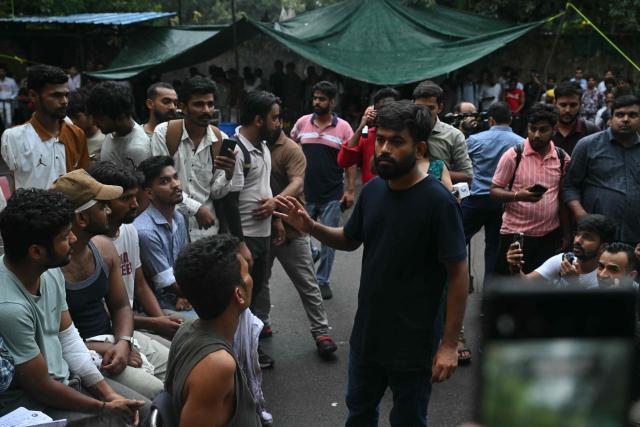 Cockroach Janta Party (CJP) founder Abhijeet Dipke speaks to victims who were injured during a protest demanding the resignation of India's Education Minister Dharmendra Pradhan over alleged NEET exam irregularities, in New Delhi on July 21, 2026. India's "Cockroach" party movement vowed on July 21 to press ahead with their campaign until Education Minister Dharmendra Pradhan resigns. (Photo by Arun SANKAR / AFP)