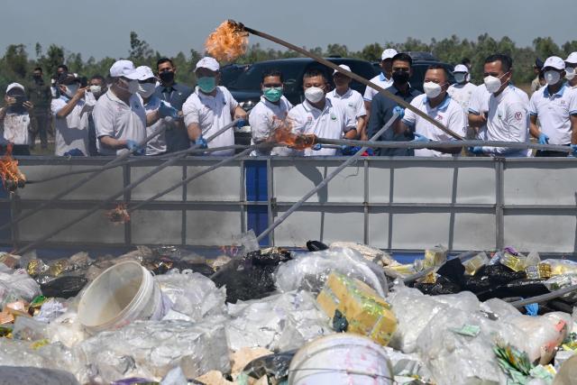 Cambodian Interior Minister Sar Sokha (2nd R) and officials burn seized drugs during a destruction ceremony to mark the UN's "International Day against Drug Abuse and Illicit Trafficking" in Kandal province on July 21, 2026. (Photo by TANG CHHIN Sothy / AFP)