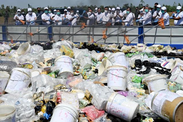 Officials burn seized drugs during a destruction ceremony to mark the UN's "International Day against Drug Abuse and Illicit Trafficking" in Kandal province on July 21, 2026. (Photo by TANG CHHIN Sothy / AFP)