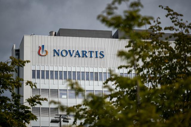 (FILES) A sign of Swiss pharmaceutical giant Novartis is seen on the top of a building at Novartis Campus in Basel on September 9, 2025. The Swiss pharmaceutical giant Novartis on July 21, 2026 reported a 19% drop in net profit for the second quarter, to $3.2 billion (Ђ3.2 billion), held back by higher interest and tax expenses. (Photo by Fabrice COFFRINI / AFP)