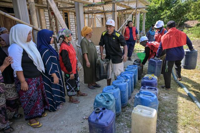 Villagers queue for clean water distributed by the Indonesian Red Cross (PMI) in Batangan village, Bangkalan Regency, East Java Province on July 21, 2026, as residents struggled to access groundwater in their homes due to a prolonged dry season - linked to this year's El Nino weather phenomenon. (Photo by JUNI KRISWANTO / AFP)