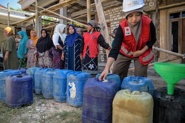 Villagers queue for clean water distributed by the Indonesian Red Cross (PMI) in Batangan village, Bangkalan Regency, East Java Province on July 21, 2026, as residents struggled to access groundwater in their homes due to a prolonged dry season - linked to this year's El Nino weather phenomenon. (Photo by JUNI KRISWANTO / AFP)