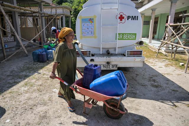 A villager moves jerrycans filled with clean water distributed by the Indonesian Red Cross (PMI) in Batangan village, Bangkalan Regency, East Java Province on July 21, 2026, as residents struggled to access groundwater in their homes due to a prolonged dry season - linked to this year's El Nino weather phenomenon. (Photo by JUNI KRISWANTO / AFP)