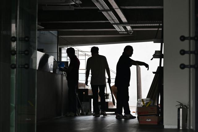 Workers carry out renovation work in a cafe in Seoul on July 21, 2026. (Photo by GREG BAKER / AFP)