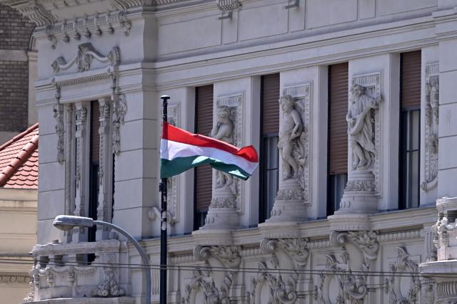 A national flag of Hungary waves over the headquarters building of Hungary's nationalist FIDESZ party of ex-leader Viktor Orban is seen in Budapest, Hungary, on July 21, 2026. The Fidesz party of Hungary's nationalist ex-leader Viktor Orban, which was swept from power in elections in April, said on July 21, 2026 that prosecutors had launched a raid on its server centre. (Photo by Attila KISBENEDEK / AFP)