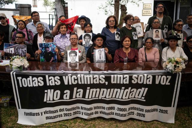 Relatives and victims of crimes committed by the Peruvian state hold portraits of victims during a press conference under the slogan "All the victims, one voice" in Lima on July 21, 2026, bringing together relatives and victims of the internal armed conflict (1980-2000), the 2020 social protests, the 2022-2023 massacres and cases of alleged state violence in 2025-2026. (Photo by Ernesto BENAVIDES / AFP)