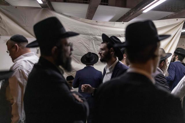 Ultra-Orthodox Jewish men pray along a street in the Orthodox Jewish neighbourhood of Ezrat Torah in Jerusalem on July 21, 2026. (Photo by ilia YEFIMOVICH / AFP)