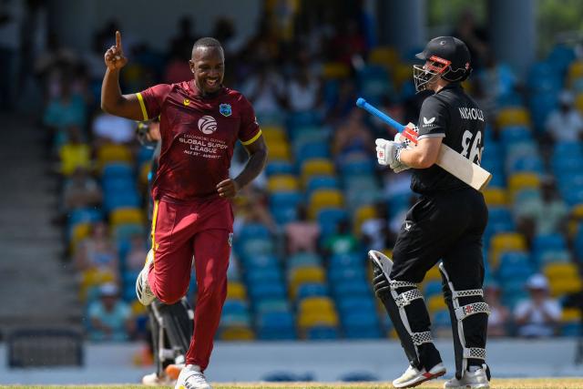 Bowler Matthew Forde (L) of West Indies celebrates the after bowling out opening batsman Henry Nicholls (R) of New Zealand for 10 runs during the fifth and final one day international (ODI) cricket match between West Indies and New Zealand at Kensington Oval in Bridgetown, Barbados on July 21, 2026. (Photo by Randy Brooks / AFP)
