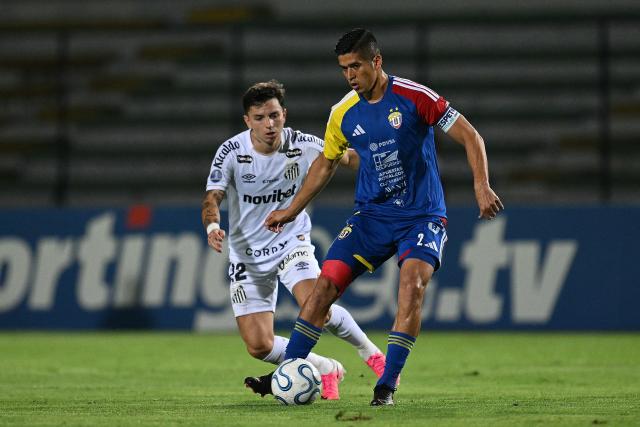 Santos' Argentine midfielderr #22 Alvaro Barreal (L) and Universidad Central's defender #02 Kendrys Silva fight for the ball during the first leg of the Copa Sudamericana knockout round play-off football match between Venezuela's Universidad Central and Brazil's Santos, at the Misael Delgado stadium in Valencia, Venezuela, on July 21, 2026. (Photo by Federico PARRA / AFP)