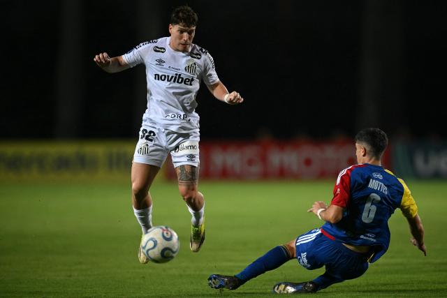 Santos' Argentine midfielder #32 Benjamin Rollheiser and Universidad Central's defender #06 Gonzalo Mottes fight for the ball during the first leg of the Copa Sudamericana knockout round play-off football match between Venezuela's Universidad Central and Brazil's Santos, at the Misael Delgado stadium in Valencia, Venezuela, on July 21, 2026. (Photo by Federico PARRA / AFP)