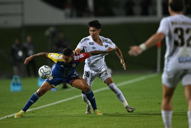 Universidad Central's defender #24 Yohan Cumana and Santos' Bolivian midfielder #30 Miguel Terceros fight for the ball during the first leg of the Copa Sudamericana knockout round play-off football match between Venezuela's Universidad Central and Brazil's Santos, at the Misael Delgado stadium in Valencia, Venezuela, on July 21, 2026. (Photo by Federico PARRA / AFP)