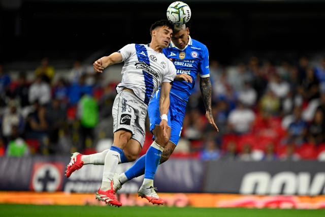 Puebla's Argentine defender #05 Facundo Almada (L) and Cruz Azul's Uruguayan forward #21 Gabriel Fernandez head the ball during the Liga MX Apertura football match between Cruz Azul and Puebla at Banorte stadium in Mexico City on July 21, 2026. (Photo by Alfredo ESTRELLA / AFP)