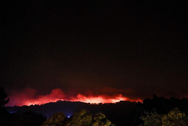 Flames consume the forest beneath a starry sky in Cotignac, southeastern France, on July 22, 2026. A wildfire advancing at surprising speed in southern France forced the evacuation of nearly 400 people from several villages on July 21, 2026, the top official for the Var region said. The evacuations took place around the villages of Cotignac, Montfort-sur-Argens and Correns, and some 1,700 hectares (4,200 acres) have already burned, the official added. (Photo by Thibaud MORITZ / AFP)
