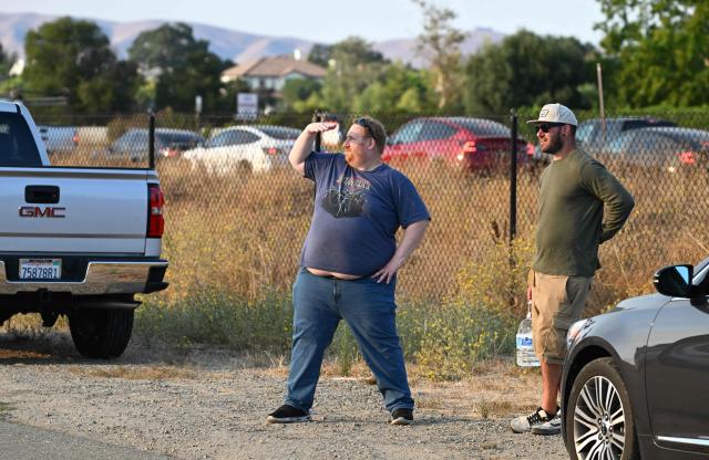 A bystander watches as flames from Little Fire burn in Pleasanton, California on July 21, 2026. (Photo by Josh Edelson / AFP)