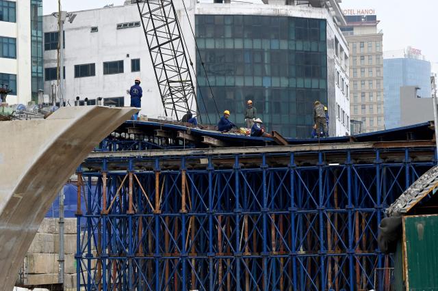 Construction workers work on a construction site in Hanoi on July 22, 2026. (Photo by Nhac NGUYEN / AFP)