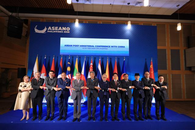 Chinese Foreign Minster Wang Yi poses for a group photo with ASEAN foreign ministers during the ASEAN Post Ministerial Conference with China on the sidelines of the Association of Southeast Asian Nations (ASEAN) Foreign Ministers' Meeting in Pasay, Metro Manila on July 22, 2026. (Photo by ELOISA LOPEZ / POOL / AFP)