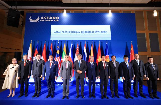 (L-R) Philippines' Foreign Secretary Theresa Lazaro, Singapore's Foreign Minister Vivian Balakrishnan, Thailand's Acting Director-General of the Department of ASEAN Affairs Vathayudh Vichankaiyakij, East Timor's Foreign Minister Bendito dos Santos Freitas, Chinese Foreign Minster Wang Yi, Malaysia's Foreign Minister Mohamad Hasan, Laos' Foreign Minister Thongsavanh Phomvihane, Brunei's Foreign Minister Prince Abdul Mateen Bolkiah, Cambodia's Foreign Minister Prak Sokhonn, Indonesia's Foreign Minister Sugiono, Myanmar's Ministry of Foreign Affairs Director-General of the ASEAN Department U Han Win Aung and ASEAN Secretary-General Kao Kim Hourn pose for a group photo during the ASEAN Post Ministerial Conference with China on the sidelines of the Association of Southeast Asian Nations (ASEAN) Foreign Ministers' Meeting in Pasay, Metro Manila on July 22, 2026. (Photo by ELOISA LOPEZ / POOL / AFP)
