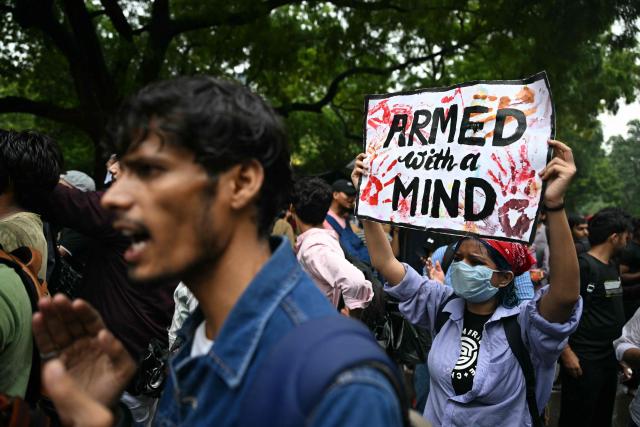 A Cockroach Janta Party (CJP) supporter holds a placard at Jantar Mantar in New Delhi on July 22, 2026 during the ongoing protest to demand the resignation of India's Education Minister Dharmendra Pradhan over alleged NEET exam irregularities. (Photo by Sajjad HUSSAIN / AFP)