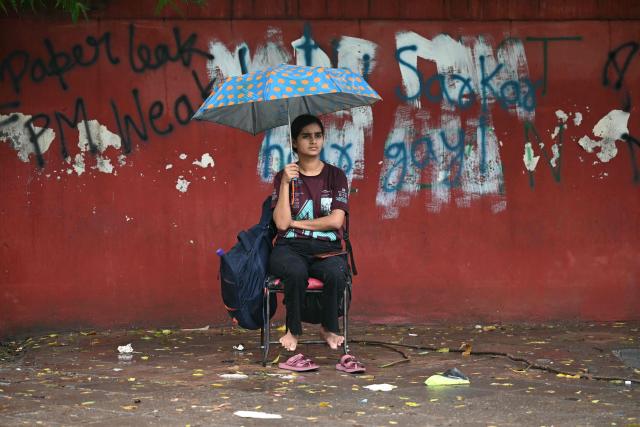 A Cockroach Janta Party (CJP) supporter sits at Jantar Mantar in New Delhi on July 22, 2026 during the ongoing protest to demand the resignation of India's Education Minister Dharmendra Pradhan over alleged NEET exam irregularities. (Photo by Sajjad HUSSAIN / AFP)