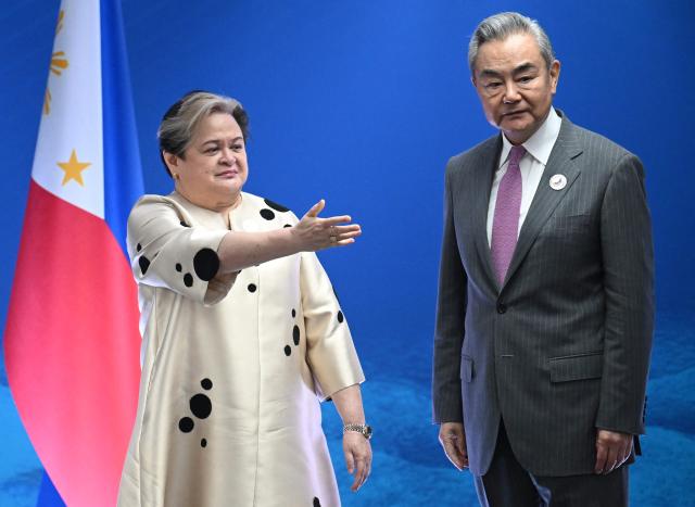 Philippine Foreign Secretary Theresa Lazaro (L) shows the way to China's Foreign Minister Wang Yi during their bilateral meeting on the sidelines of the Association of Southeast Asian Nations (ASEAN) Foreign Ministers' Meeting in Pasay, Metro Manila on July 22, 2026. (Photo by Ted ALJIBE / POOL / AFP)