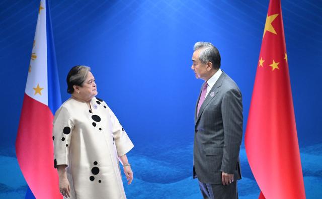 Philippine Foreign Secretary Theresa Lazaro (L) talks to China's Foreign Minister Wang Yi during their bilateral meeting on the sidelines of the Association of Southeast Asian Nations (ASEAN) Foreign Ministers' Meeting in Pasay, Metro Manila on July 22, 2026. (Photo by Ted ALJIBE / POOL / AFP)