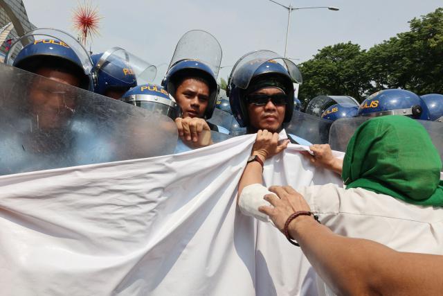 Demonstrators push back against police as they protest US Secretary of State Marco Rubio's visit to the Philippines to attend the Association of Southeast Asian Nations (ASEAN) Foreign Ministers' Meeting outside the meeting venue in Pasay, Metro Manila on July 22, 2026. (Photo by Bullit MARQUEZ / AFP)