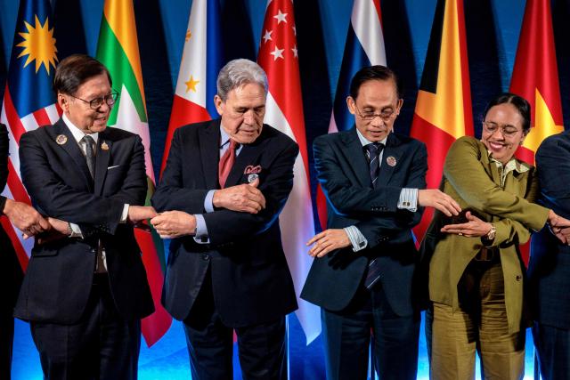 New Zealand's Foreign Minister Winston Peters (2nd L) links hands with Thailand's Deputy Prime Minister and Foreign Minister Sihasak Phuangketkeow (L) and Vietnam's Foreign Minister Le Hoai Trung (2nd R) as they pose for a group photo during the ASEAN Post-Ministerial Conference with New Zealand on the sidelines of the ASEAN Foreign Ministers' Meeting at the Philippine International Convention Center in Pasay, Metro Manila on July 22, 2026. (Photo by Ezra Acayan / POOL / AFP)