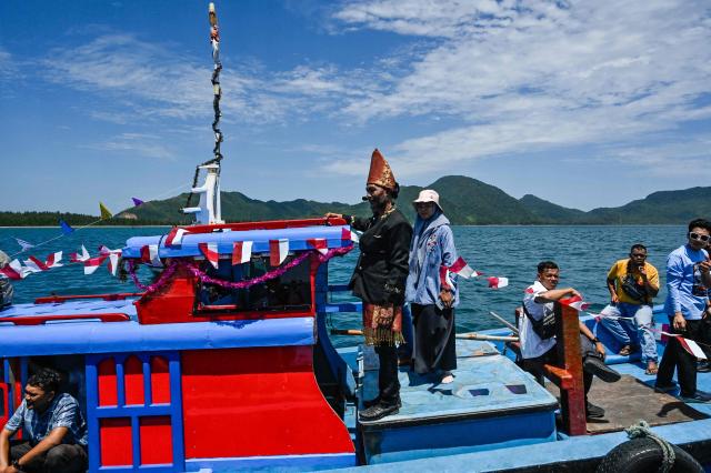 Indonesian fishermen take part in the traditional festival known as "Kenduri Laot," a maritime feast held as an expression of gratitude for the ocean, off the coast of Banda Aceh on July 22, 2026. (Photo by CHAIDEER MAHYUDDIN / AFP)