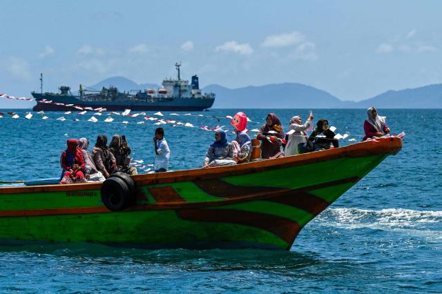 Indonesian fishermen take part in the traditional festival known as "Kenduri Laot," a maritime feast held as an expression of gratitude for the ocean, off the coast of Banda Aceh on July 22, 2026. (Photo by CHAIDEER MAHYUDDIN / AFP)