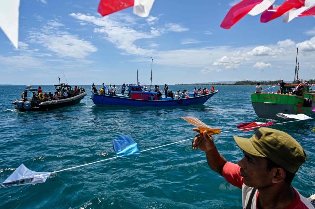 Indonesian fishermen take part in the traditional festival known as "Kenduri Laot," a maritime feast held as an expression of gratitude for the ocean, off the coast of Banda Aceh on July 22, 2026. (Photo by CHAIDEER MAHYUDDIN / AFP)