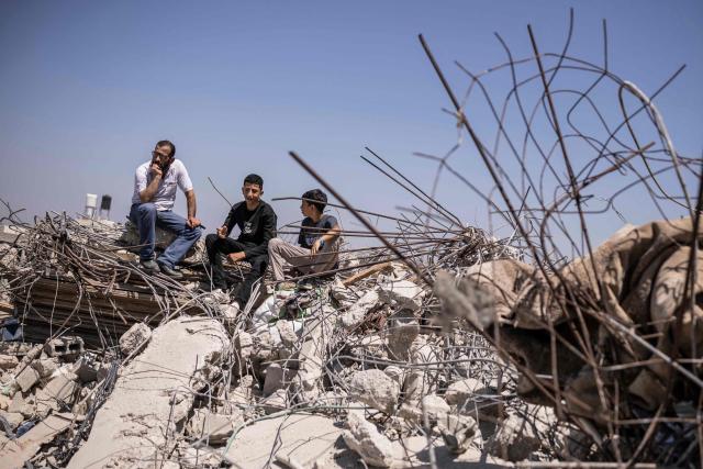Palestinians sit on the ruins of a home that was demolished by Israeli security forces in the village of Nahalin, southwest of Bethlehem in the Israeli occupied West Bank on July 22, 2026. Since the start of the Gaza war in October 2023, violence has escalated in the West Bank. (Photo by JOHN WESSELS / AFP)