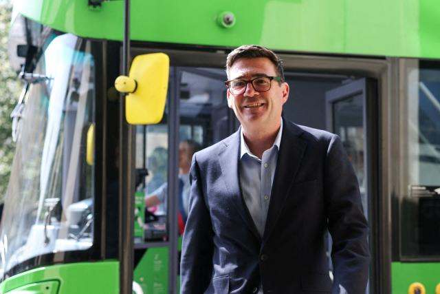 Britain's Prime Minister Andy Burnham disembarks a bus after a ride in central Bath, western England, on July 22, 2026. Burnham, who became prime minister on July 20, pledged on July 22 to ease cost-of-living pressures, unveiling a tax cut on household electricity prices and a £2 (2.70 USD) cap on single bus fares in his first days in the job. (Photo by Toby Melville / POOL / AFP)